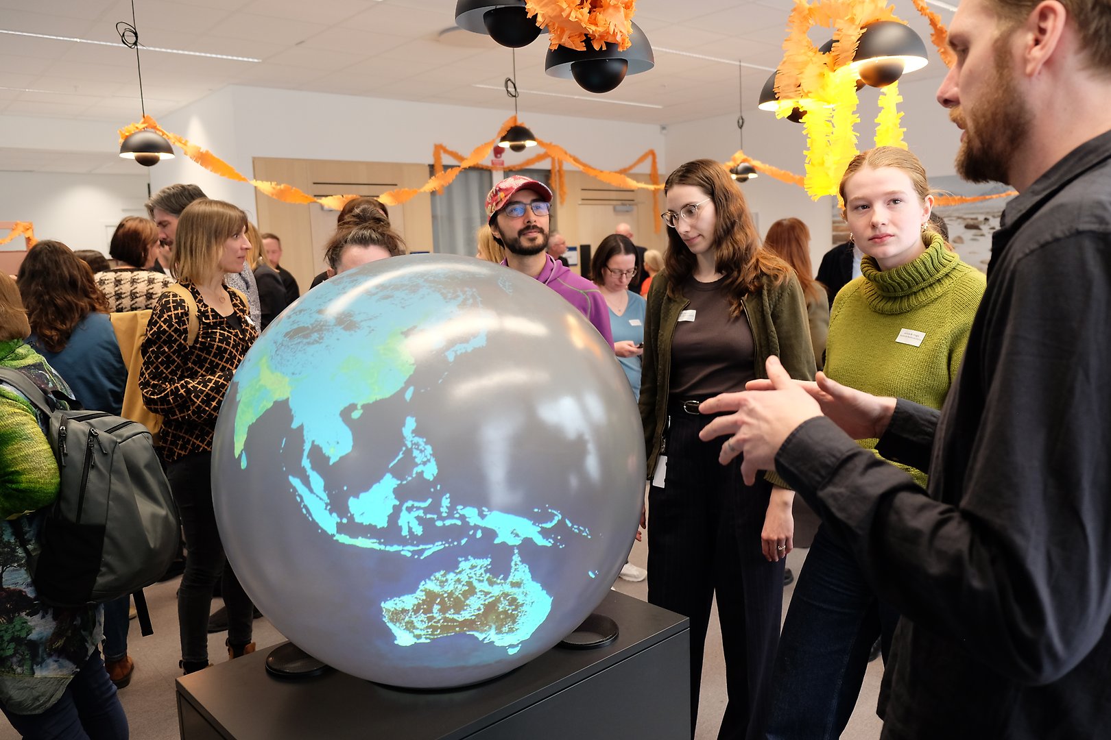 Four people around a big globe