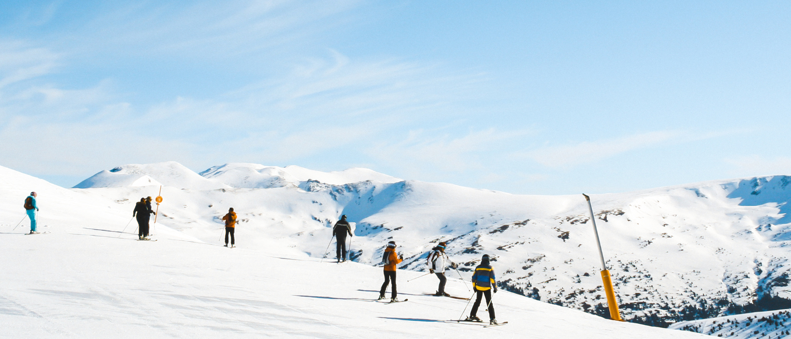 Alpine skiers on top of a ski slope